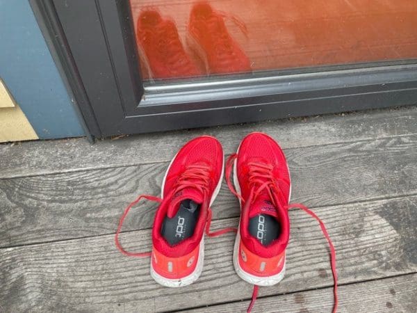 bright red shoes on a wooden porch in front of an orange door