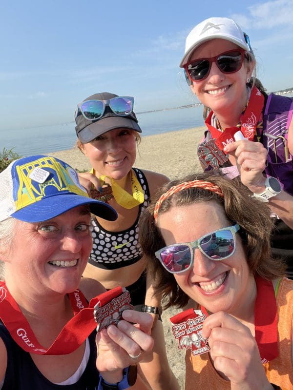 Four women runners on the shore