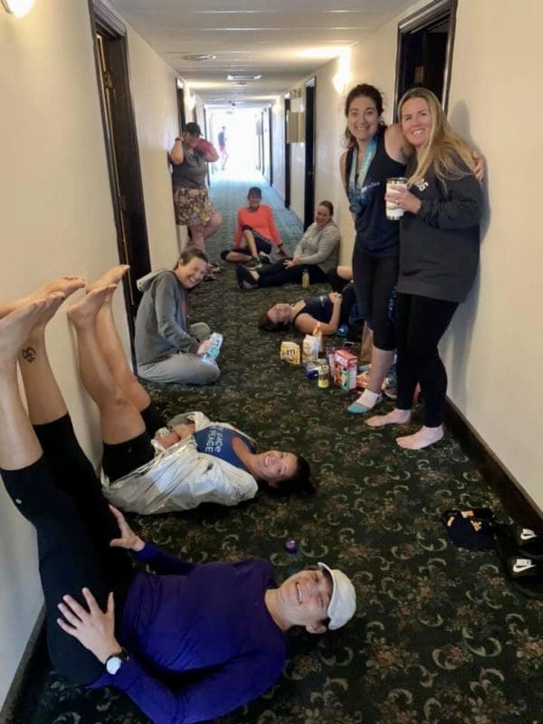Women in running clothes lounging in a hallway