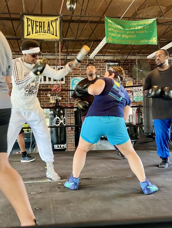 a woman training with a coach in a boxing ring